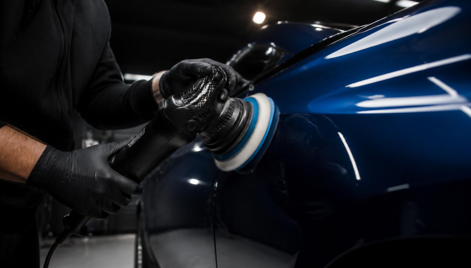 Polijstmachine op een autopaneel met spiegelende glans